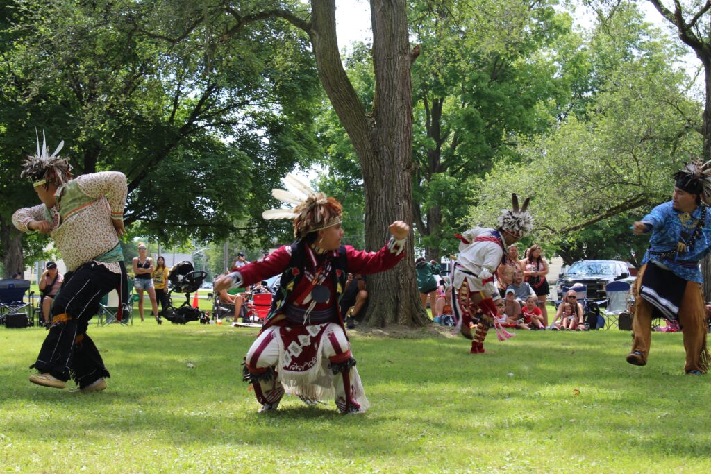Three indigenous women traditionally dressed standing in the grass